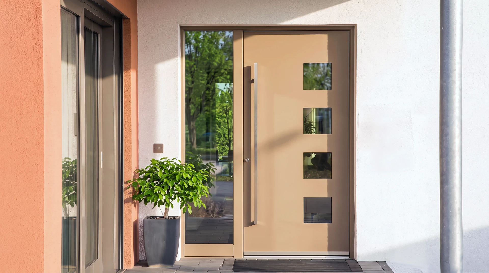 Entrée extérieure de maison moderne avec porte d'entrée contemporaine noire à panneau vitré supérieur et poignée métallique dorée